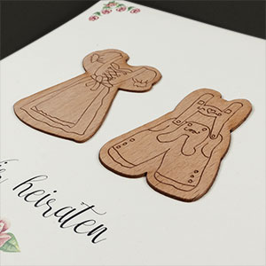 Vergrößerte Abbildung Auf die weiße Karte aufgeklebte Holzapplikationen.