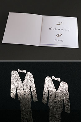 Liegende, aufgeklappte Einladungskarte mit eingestecktem, bedruckten Texteinleger.